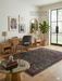 5' x 8' Rectangular Black Multi Color Distressed Ornate Vintage Traditional Area Rug styled in a home office.