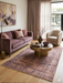 5' x 8' Rectangular Brown Beige Distressed Modern Abstract Area Rug styled in a contemporary living room with mauve sofa and round brass coffee table.