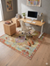 5' x 8' Rectangular Multicolor Distressed Tribal Geometric Vintage Washable Area Rug styled in a home office with a light wood desk, modern chair, and minimal decor.