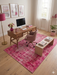 5' x 8' Rectangular Pink Distressed Oriental Vintage Area Rug styled in a stylish home office with modern pink furnishings.
