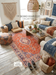 5' x 8' Rectangular Red & Blue Floral Medallion Traditional Persian Washable Area Rug placed in a boho-style living room with sofa, floor cushions, and rustic coffee table.