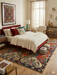 5' x 8' Rectangular Red Multi Color Geometric Floral Tribal Vintage Area Rug styled in a bedroom.