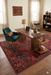 5' x 8' Rectangular Red & Navy Tribal Geometric Traditional Washable Area Rug styled in a home office with a wooden desk, shelving, and warm natural light.