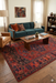 5' x 8' Rectangular Red & Navy Tribal Geometric Traditional Washable Area Rug styled in a living room with a sofa, accent chairs, and warm-toned decor.