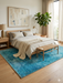 5' x 8' Rectangular Teal & Aqua Distressed Abstract Modern Area Rug styled in a bedroom with layered neutral bedding and warm wood accents.