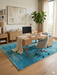 5' x 8' Rectangular Teal & Aqua Distressed Abstract Modern Area Rug styled in a home office with a wooden desk and natural light.