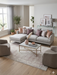 5' x 8' rectangular beige & ivory distressed oriental vintage area rug styled in a bright living room with a neutral sofa and soft accent pillows.