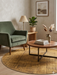 6' Round Gold & Brown Distressed Abstract Modern Washable Area Rug styled in a cozy living space with a green accent chair, wood table, and warm neutral decor.