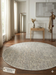6' Round Ivory & Gray Geometric Textured Washable Area Rug styled in a modern entryway with console table, mirror, and coat rack.