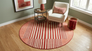 6' Round Red Ivory Striped Modern Contemporary Area Rug featured in a cozy reading nook with an accent chair and round side table.