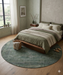6' Round Sage Green Distressed Oriental Vintage Area Rug placed in a serene bedroom with earthy green bedding and soft natural lighting.