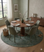 6' Round Sage Green Distressed Oriental Vintage Area Rug showcased in a contemporary dining room with a round wooden table and muted green chairs.