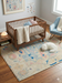 6' x 6' Square Ivory & Blue Tribal Medallion Traditional Area Rug styled in a cozy nursery with wooden crib and soft pastel décor.