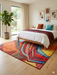 6' x 6' Square Multicolor Modern Abstract Geometric Area Rug styled in a bedroom with bright accent pillows and natural light.