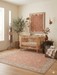 6' x 6' Square Peach & Ivory Floral Medallion Traditional Washable Area Rug styled in a cozy nursery beneath a wooden crib.