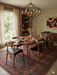 6' x 6' square red & charcoal tribal geometric southwestern area rug styled in a dining room with a wooden table and modern rustic decor.