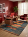 6' x 9' Rectangular Blue & Orange Geometric Modern Area Rug styled in a home office with bold wall color and contemporary decor.