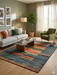 6' x 9' Rectangular Blue & Orange Geometric Modern Area Rug styled in a living room with neutral seating and warm accent tones.