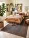 6' x 9' Rectangular Dark Brown & Rust Tribal Border Traditional Washable Area Rug styled in a bedroom with a wooden bed, layered bedding, and wall decor.