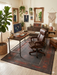 6' x 9' Rectangular Dark Brown & Rust Tribal Border Traditional Washable Area Rug styled in a home office with a desk, chair, and indoor plants.