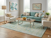 6' x 9' Rectangular Mint Green Distressed Medallion Traditional Washable Area Rug styled in a bright living room with a mint sofa, cream accent chairs, and light wood floors.