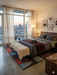 6' x 9' Rectangular Multicolor Red Blue & Charcoal Abstract Geometric Modern Area Rug styled in a bedroom with a modern bed and neutral decor.