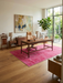 6' x 9' Rectangular Pink & Rose Distressed Vintage Washable Area Rug styled in a home office with natural light and indoor plants.
