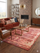 6' x 9' Rectangular Rust Pink Southwestern Tribal Geometric Area Rug featured in a living room with a sofa, coffee table, and brick fireplace backdrop.