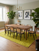 6' x 9' Rectangular Yellow Distressed Minimalist Modern Washable Area Rug styled in a dining room with a wooden table and chairs.