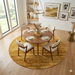 7' Round Gold & Beige Distressed Abstract Modern Area Rug placed in a contemporary dining room beneath a round wooden dining table.