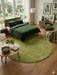 7 ft Round Green Solid Shag Modern Contemporary Area Rug styled in a modern bedroom.