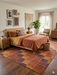 7' x 10' Rectangular Brown & Rust Checkered Geometric Modern Washable Area Rug styled in a bedroom with warm-toned bedding and natural wood accents.