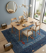 7' x 10' Rectangular Gray & Blue Solid Textured Modern Area Rug styled under a dining table in a bright dining room.