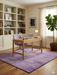 7' x 7' Square Purple Distressed Grid Geometric Modern Area Rug styled in a home office with a wooden desk and shelving.