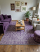 7' x 9' Rectangular Ivory & Purple Floral Medallion Traditional Area Rug placed in a cozy living room with a plum velvet sofa and botanical wall art.