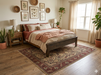 7' x 9' Rectangular Ivory Red Floral Medallion Traditional Washable Area Rug placed in a warm farmhouse bedroom with a dark wood bed, layered neutral bedding, and botanical wall art.