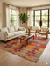 7' x 9' Rectangular Orange Multi Color Geometric Tribal Southwestern Area Rug styled in a living room with modern furniture and coordinated decor.