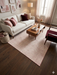 7' x 9' Rectangular Pink Ivory Solid Modern Area Rug displayed in a bedroom setting beneath a bed with coordinating pink décor.
