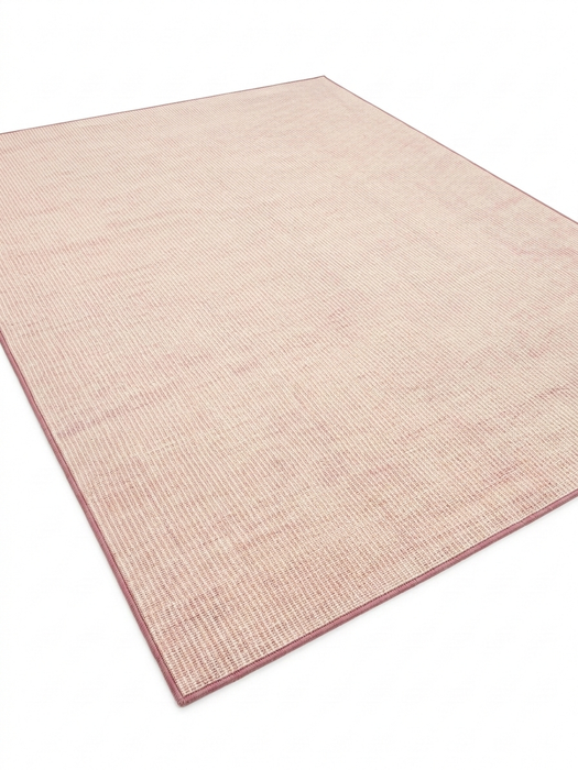 7' x 9' Rectangular Pink Ivory Solid Modern Area Rug shown in a modern living room with neutral sofa, wooden coffee table, and blush accent pillows.