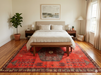 7' x 9' Rectangular Red & Charcoal Tribal Geometric Southwestern Area Rug placed beneath a bed in a minimalist bedroom.