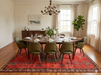 7' x 9' Rectangular Red & Charcoal Tribal Geometric Southwestern Area Rug styled under a dining table in an elegant dining room.