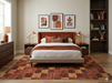 7' x 9' Rectangular Rust Gold Checkered Geometric Modern Washable Area Rug placed under a bed in a modern bedroom with rich rust accents and dark wood furniture.