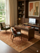 7' x 9' Rectangular Rust Gold Distressed Floral Medallion Vintage Traditional Area Rug styled in a home office with wood furniture and large windows.