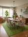 7' x 9' rectangular green textured micro dot modern area rug placed in a dining room with a wooden table, upholstered chairs, and modern lighting.