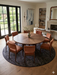 8' Round Charcoal Gray Textured Abstract Modern Washable Area Rug styled in a dining room with a round table and upholstered chairs.