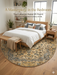 8' Round Ivory & Blue Floral Medallion Traditional Area Rug placed in a bedroom under a bed with light wood furniture and soft neutral bedding.