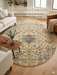 8' Round Ivory & Blue Floral Medallion Traditional Area Rug placed in a living room with a sofa, accent chair, and natural wood coffee table.