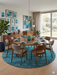 8' Round Teal & Charcoal Distressed Modern Washable Area Rug styled in a bright dining room beneath a round wooden dining table with coordinated teal décor.