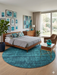 8' Round Teal & Charcoal Distressed Modern Washable Area Rug styled in a modern bedroom with a wooden bed frame, accent chair, and teal wall art.