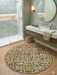 8' round multicolor geometric triangle pattern modern area rug styled in a bathroom with a floating vanity and walk-in shower.